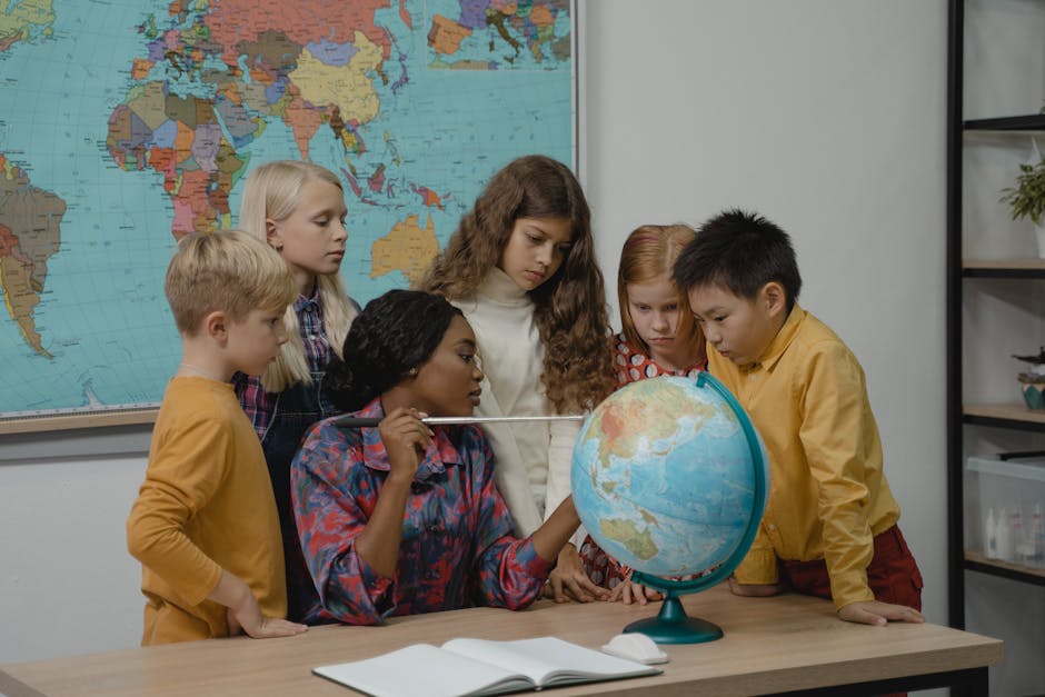 A diverse group of children learning geography with a teacher and globe in a classroom