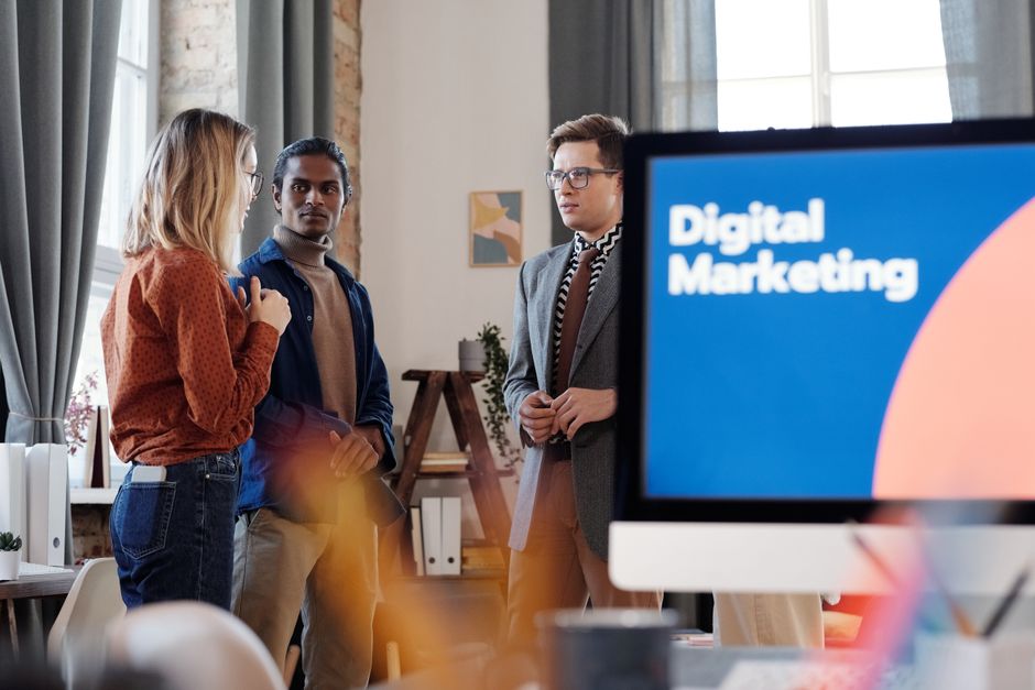 Group of colleagues discussing digital marketing strategies in an office setting